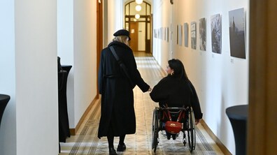 дві жінки спілкуються в коридорах міської Ратуші, одна з них на кріслі колісному