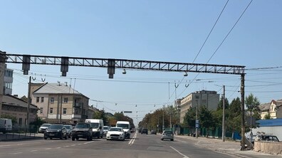 Вулиця Городоцька у напрямку виїзду з міста. З лівого боку дороги рухаються автомобілі і мікроавтобуси, а по обидва боки вулиці розташовані житлові будівлі. Над проїжджою частиною простягаються тролейбусні контактні мережі та металева конструкція для дорожнього обладнання.