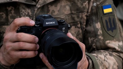 Ілюстративне фото. Чоловік у військовій формі тримає в руках камеру