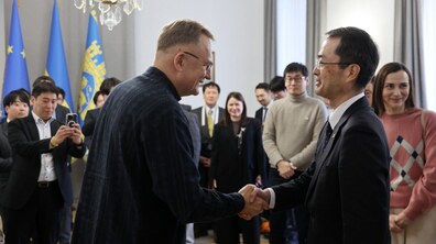 Мер Львова Андрій Садовий тисне руку одному з представників японської делегації в кабінеті мера у Львівській ратуші. Довкола кілька десятків представників японського бізнесу