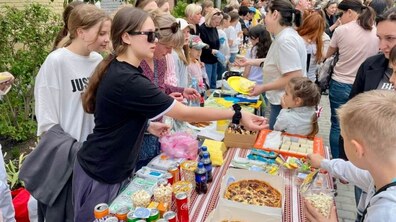 Діти на шкільному ярмарку продають різну продукцію.
