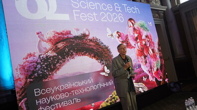 Лауреат Нобелівської премії Свенте Паабо під час виступу на Всеукраїнському науково-технологічному фестивалі OL Science & Tech Fest 2026. Науковець стоїть на сцені з мікрофоном у руках, звертаючись до учасників заходу. Позаду нього — великий екран із символікою фестивалю та яскравою візуалізацією