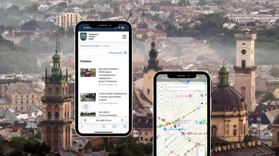 Ілюстративне фото. На фоні центр Львова з висоти. Попереду два смартфони: із новинами Львова та із картою маршрутів громадського транспорту