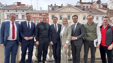 На балконі міського голови Львова стоять Андрій Садовий та ще семеро осіб. Усі усміхаються, на фоні - фасади львівських будинків
