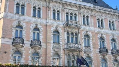 Головний фасад готелю «Жорж» у Львові. Будівля багатоповерхова та пофарбована у світло-рожевий та кремовий кольори.