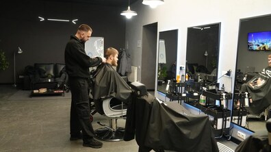 перукар в барбершопі робить стрижку
