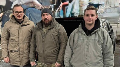 Перший заступник міського голови Львова Андрій Москаленко разом з чоловіком у військовій формі, та чоловіком у цивільному вбранні. Позаду них видно автомобіль.