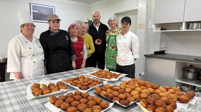 Представники профтеху та модульного містечка стоять біля столу, на якому є багато готових пампухів