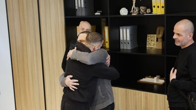 Микола, син донора, та один із реципієнтів, якому пересадили органи, обіймають один одного у лікарні; поруч стоять ще двоє реципієнтів