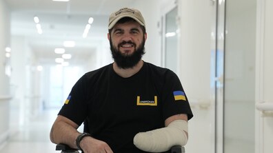 Захисник Андрій Круль сидить на кріслі в холі центру UNBROKEN та усміхається