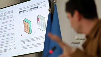 На екрані візуалізація оновленого вигляду апарату для продажів. Про єдиний стандарт за трибуною розповідає Роман Крушельницький, начальник управління архітектури Львівської міської ради.