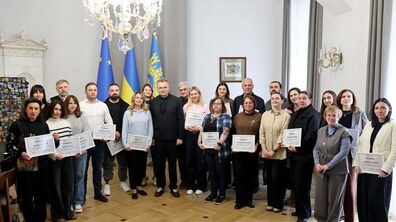 Спільне фото: учасники Резиденції, мер Львова Андрій Садовий та організатори Резиденції стоять у кабінеті міського голови; учасники тримають в руках сертифікати про участь у події. Позаду видно великі прапори.