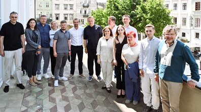 На спільному фото: учасники резиденції, мер Львова Андрій Садовий та депутати Львівської міської ради. Усі дивляться в камеру та усміхаються. Фото зроблене на балконі Ратуші.