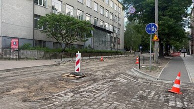 Вул. Героїв УПА під час ремонту. Старе дорожнє покриття демонтоване, місцями видно бруківку та підготовлену основу дороги. Уздовж вулиці встановлені дорожні конуси й огородження. Ліворуч розташована багатоповерхова будівля, праворуч — тротуар і велопішохідна доріжка, обсаджені деревами.