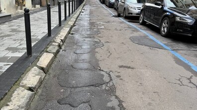 Стан дорожнього покриття вулиці, уздовж - припарковані автомобілі
