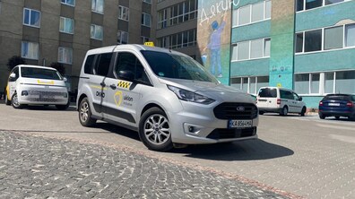 інклюзивне таксі біля лікарні. Позаду видно інші автомобілі.
