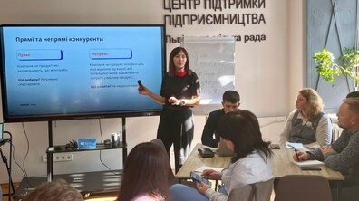 під час навчання лекторка розповідає матеріал біля мультимедійної дошки
