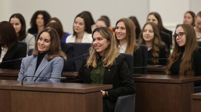 Кілька десятків жінок за столами у Великій сесійній залі Львівської міської ради слухають виступ та посміхаються