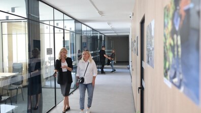 Дві жінки розмовляють, ідучи приміщенням Львівського центру надання послуг учасникам бойових дій на вул. Липинського, позаду також розмовляють двоє людей