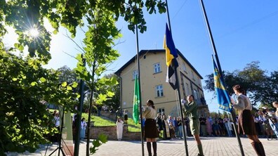 Пластуни піднімають прапори біля нової домівки Пласту.