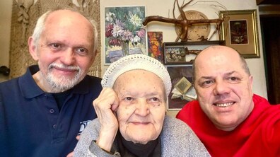 Довгожителька Ніна Сукачева, її родич та соціальний працівник Іван Фасольник у кімнаті ювілярки: усі троє усміхаються