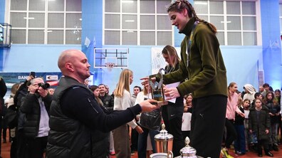 Директор Офісу спорту ЛМР Антон Нікулін вручає нагороду Ярославі Магучіх. Позаду інші учасники, глядачі та журналісти.