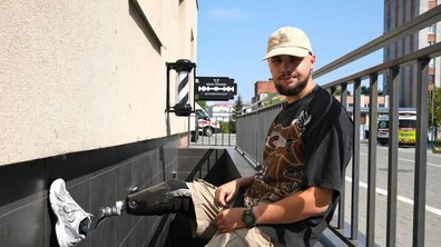 Ветеран Василь Курило біля входу до свого безбар’єрного барбершопу Iron Wings у лікарні Святого Пантелеймона. На фото видно його протез ноги та простір, адаптований для комфортного доступу відвідувачів.