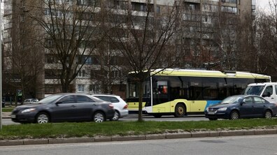 Тролейбус і автомобілі їдуть по вулиці
