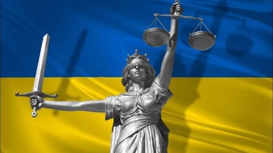 ілюстративне зображення Феміди на фоні прапора України.